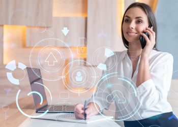 Attractive businesswoman in white shirt has conference call to optimize development by implying new technologies in business process. Hi tech hologram over office background